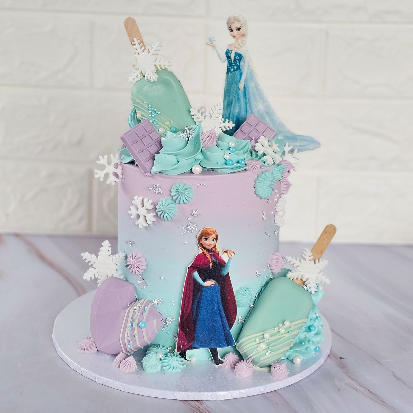 Lilac and mint ice princess cake with snowflakes and ice lollies
